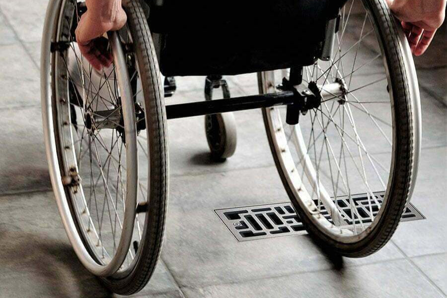 Person using a wheelchair on a tiled floor with Ventiques Original Tornado Brushed Platinum flush mount vent